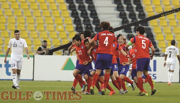 South Korean players celebrate scoring the only goal of their match against Jordan in the AFC U23 Championship quarter-finals yesterday. At right, Jordanian players show their disappointment after their exit from the tournament. Pictures: Mamdouh