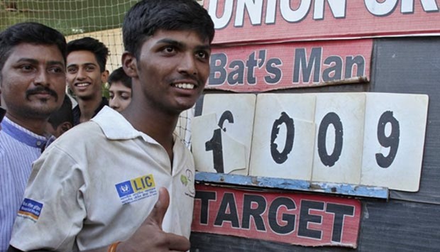 Pranav Dhanawade, 15, gestures as he poses next to the scoreboard during an inter-school cricket tournament in Mumbai this week.