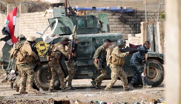 Iraqi forces take position as they advance in Mosul's eastern Al-Intisar neighbourhood on Saturday.