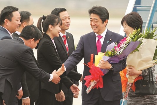 Japanu2019s Prime Minister Shinzo Abe and his wife Akie shake hands with Vietnamese security personnel before their departure from the Noi Bai international airport in Hanoi yesterday.