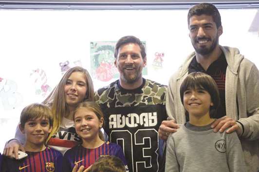 Barcelonau2019s Lionel Messi (centre) and Luis Suarez (right) pose with children at the Sant Pau hospital in Barcelona yesterday. (AFP)