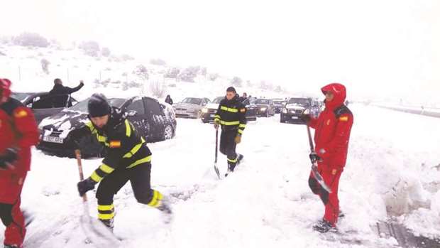 A handout picture released yesterday by the Spanish armyu2019s emergency unit UME shows personnel working to free cars stuck on the AP6 highway after a heavy snowfall.