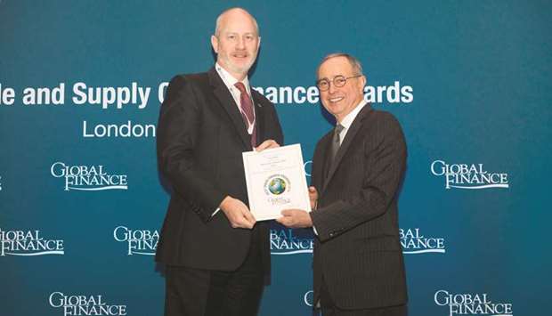 Whiting (left) receives the award on behalf of Doha Bank from Giarraputo in London recently.