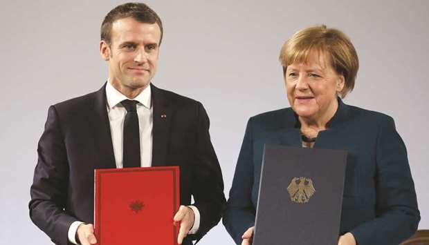 Macron and Merkel pose with the signed French-German friendship treaty, in the town hall of Aachen, western Germany.