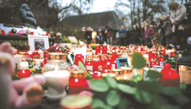 A picture taken yesterday shows flowers and candles left at a makeshift memorial site in front of the burned-out monkey house at Krefeld zoo.