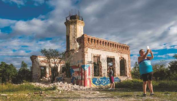 Tourists take pictures of the collapsed wall of the ruins of an iconic landmark lighthouse in Guanica, Puerto Rico on Monday after it was destroyed by an earthquake.