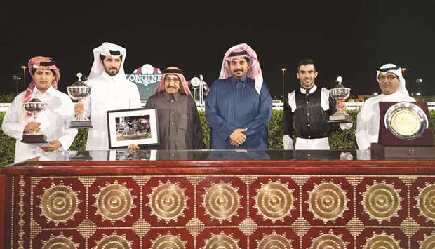 Khalifa bin Issa Bojamhoor al-Hassan al-Mohannadi (third from left) and Qatar Racing and Equestrian Club CEO Nasser Sherida al-Kaabi (third from right) with the winners of the Al Thakhira Cup after Raqee won the 1,200m race at Al Rayyan Park yesterday. PICTURES: Juhaim