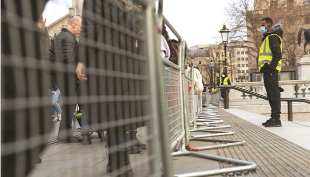 Security guards stand by the temporary fencing around the perimeter of Trafalgar Square, to prevent crowds gathering on New Yearu2019s Eve, in London, yesterday.