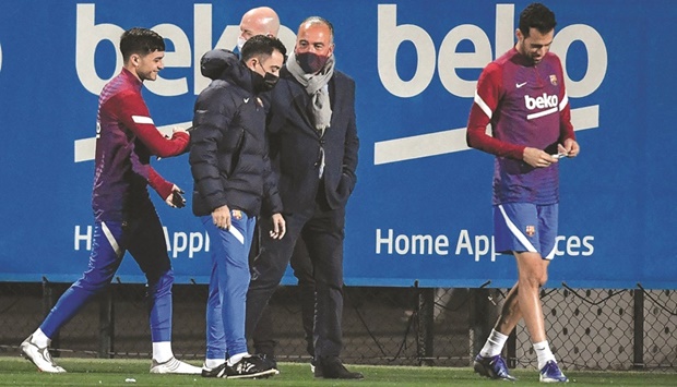 Barcelonau2019s first vice-president Rafael Yuste (centre) speaks with coach Xavi during a training session in Barcelona yesterday. (AFP)