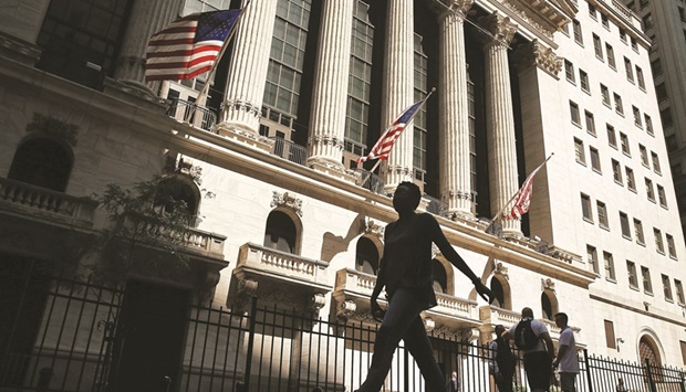 People walk by the New York Stock Exchange. A steep slide in US stocks has investors gauging equity valuations to determine whether now is the time to scoop up shares at a bargain.