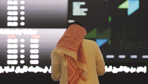 A Saudi investor monitors share prices at the Saudi Stock Exchange, or Tadawul, in the capital Riyadh (file). Share sales in Saudi Arabia have seen huge investor demand, with most IPOs getting priced at the top of offering ranges and surging on their trading debut. The Saudi benchmark index has jumped about 9% this year, extending its 2021 gains of 30%.