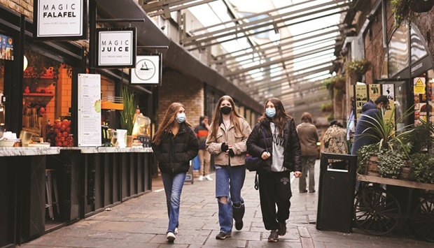 Shoppers wearing face coverings to combat the spread of the coronavirus, walk past stores in Camden Market in London as UK businesses and consumers face mounting fallout from surging inflation, including higher interest rates.