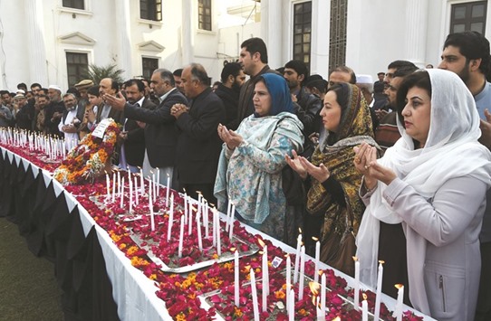 Legislators pray beside lighted candles as they pay tribute to victims on the second anniversary of an attack on the Army Public School in the city of Peshawar yesterday.