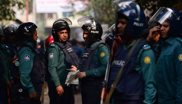 Bangladesh police officials stand alert at the scene