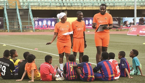 Members of the coaching crew speak to students of the FCB Escola soccer school during a training session at Teslim Balogun Stadium in Lagos.