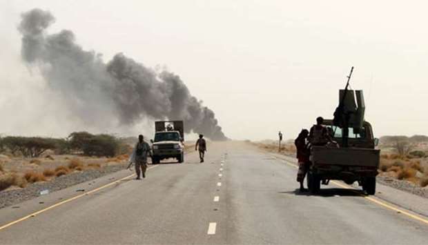 Yemeni fighters loyal to the Saudi-backed Yemeni president are seen with their vehicles on the road leading to the town of Khokha which was retaken from Houthi rebels.