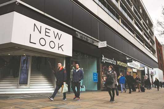 Pedestrians walk past a New Look fashion store in London. Hedge fund Sona  Asset Management and JPMorgan Chase & Co have flagged risks from a  possible restructuring by New Look because of flaws in the way credit-default swaps are designed to compensate for losses.