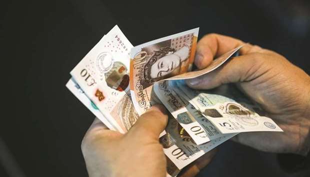 A man holds pound sterling banknotes in an arranged photograph in London. Speculation has been growing that sterling will plummet if parliament were to reject the divorce pact on December 11.