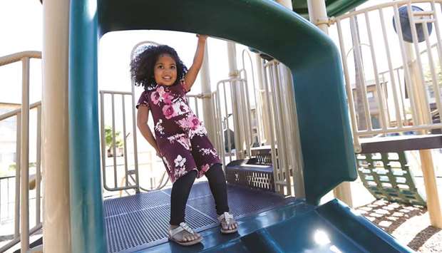 RESTRICTED MOVEMENT: Maipele Burns, 4, prepares to go down the slide while playing in the park across the street from her home in Camarillo, California. Maipele was diagnosed at the age of 2 with acute flaccid myelitis, causing permanent paralysis in her right arm.