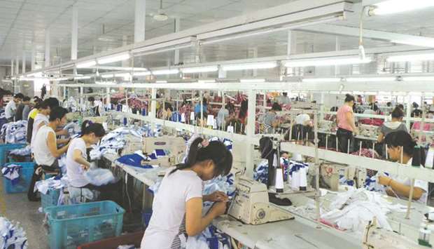 Workers make Orolay jackets at the companyu2019s factory complex in Jiaxing, Zhejiang province. Chinau2019s economic growth cooled to a near 30-year low of 6% in the third quarter, and could slip further in the fourth, but remains on track to meet the lower end of the governmentu2019s full-year target of 6-6.5%.