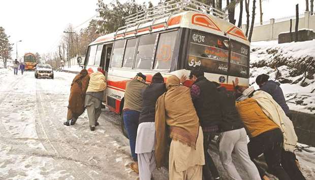 Tourists push their mini bus on a street covered with snow in Murree, some 65km north of Islamabad.