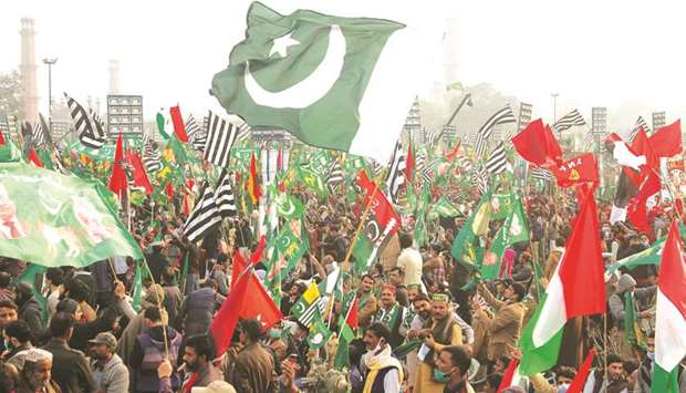 Supporters of the Pakistan Democratic Movement (PDM), an alliance of political opposition parties, wave flags as they listen to the speeches by their leaders during a protest rally yesterday in Lahore.