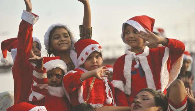 Children dressed as Santa Claus ride on a camel cart at a rally ahead of the Christmas celebrations in Karachi. (AFP)