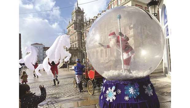 A man dressed up as Santa Claus waves to children from inside a plastic ball as a protective measure against the coronavirus disease (Covid-19), in Ferrol, in the northwestern Spanish region of Galicia.