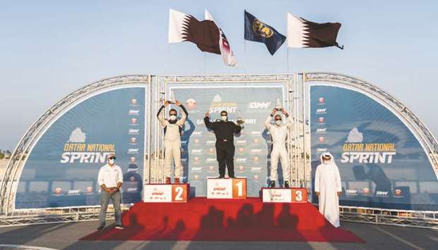 The Qatar Motor & Motorcycle Federation (QMMF) President Abdulrahman al-Mannai and Executive Director Amro al-Hamad pose with the overall winners of the 2020 Qatar National Sprint Championship, the fifth and final round of which was held at Losail on Saturday