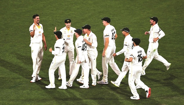 Australian fast bowler Mitchell Starc (left) is congratulated by his teammates after dismissing Englandu2019s opening batsman Rory Burns (not in picture) during the day two of the second Ashes Test in Adelaide yesterday. (AFP)