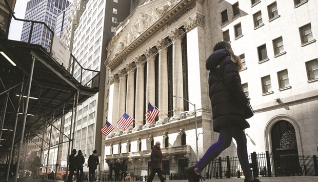 People are seen on Wall Street outside the New York Stock Exchange. Investors are scrutinising the stock marketu2019s narrowing breadth and other signs of ebbing risk appetite, as markets digest a hawkish pivot from the Federal Reserve, soaring inflation and concern over a fresh wave of Covid-19 cases.