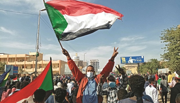 A protester waves the national flag during a rally in Khartoum to mark three years since the start of mass demonstrations that led to the ouster of strongman Omar al-Bashir.