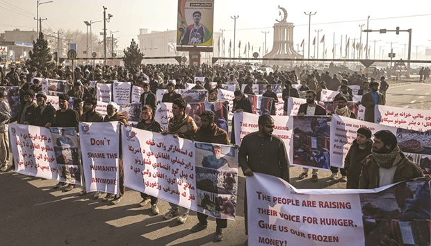 People hold banners before marching on the street during a protest in Kabul.