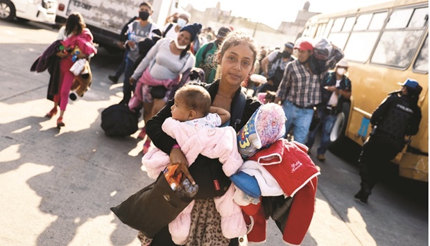 Migrants leave a shelter, along other members of a migrant caravan that left  southern Mexico two months ago, and begin their journey to northern Mexico in buses after receiving their humanitarian visas to transit throughout the country, in Mexico City.