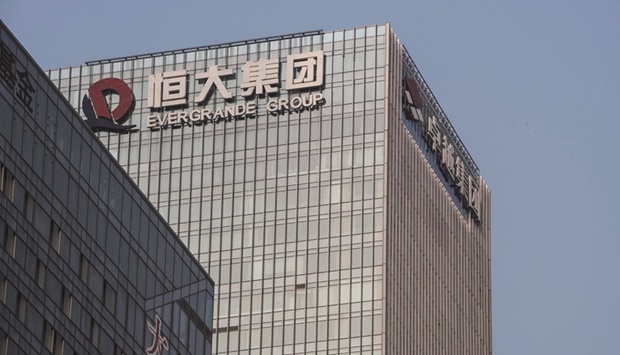 The China Evergrande Group logo displayed atop the companyu2019s headquarters in Shenzhen. Evergrande said it has resumed construction at most of its housing projects as authorities push the debt-laden developer to pay migrant workers and deliver apartments.