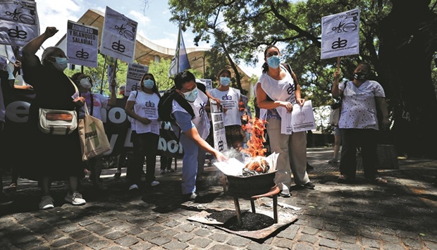 Healthcare workers set copies of pay stubs on fire during a protest for better salaries outside the Buenos Airesu2019 city government house, amid a spike in the coronavirus (Covid-19) cases.