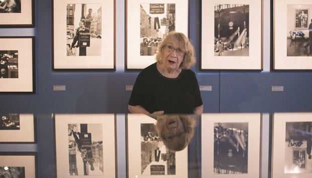 This file photo taken in Vannes on July 16, 2020 shows Swiss-French photographer Sabine Weiss posing in front of her pictures as she visited a retrospective exhibition of her work. (AFP)