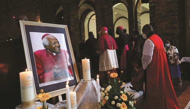 Clergymen walk past a portrait of South African anti-apartheid icon Archbishop Desmond Tutu during an interfaith service in honour of him at St Albans Cathedral in Pretoria, yesterday.