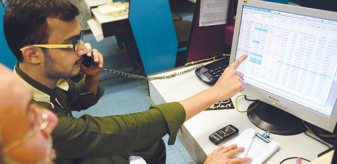 Pakistani stockbrokers monitor share prices during a trading session at the Karachi Stock Exchange yesterday.