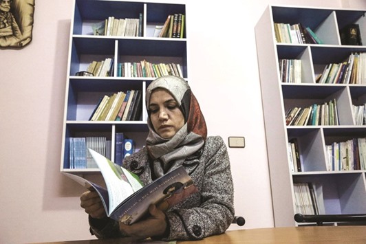 A Kurdish woman reads a book at a library in Kurdish-majority Qamishli in northeast Syria.