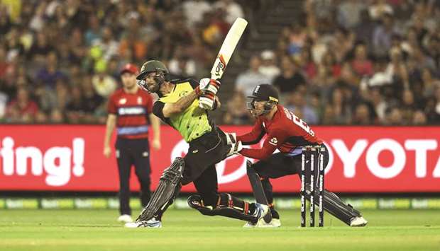 Australiau2019s batsman Glenn Maxwell plays a shot as Englandu2019s wicketkeeper Jos Buttler looks on during the Twenty20 International Tri-Series match at the MCG in Melbourne yesterday. (AFP)