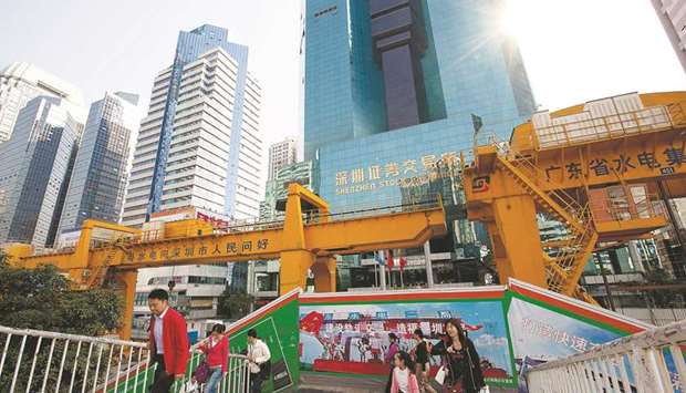 Pedestrians walk in front of the Shenzhen Stock Exchange building in China. The bourse offered more money for a 25% stake in the Dhaka Stock Exchange and also sweetened its bid with nearly $40mn worth of technical assistance, according to reports.