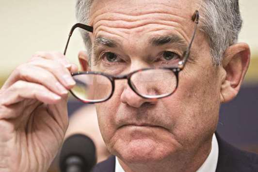 Jerome Powell, chairman of the US Federal Reserve, puts on his glasses during a House Financial Services Committee hearing in Washington, DC, on Tuesday. Powell moved markets with his upbeat economic assessment, and also dropped some hints about how his views and style might differ from his predecessor, Janet Yellen.
