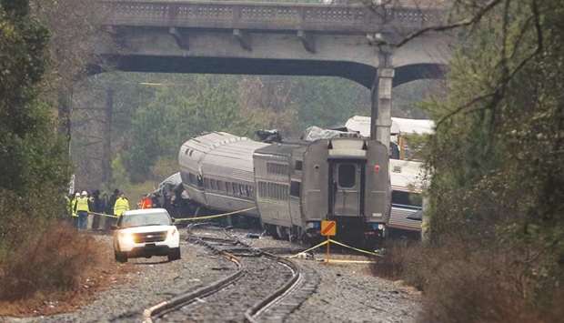 Investigators make their way around the train wreckage under the Charleston Highway overpass in Cayce, South Carolina.