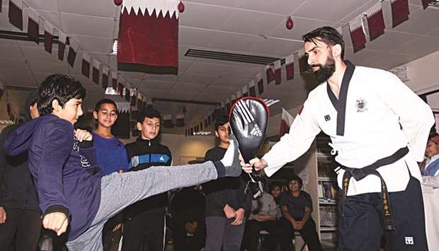 Taekwondo athlete Othman Abdelmalik trains a student during his visit to Umm Al Qura boysu2019 school.