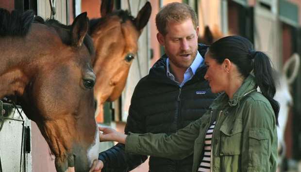 Prince Harry and his wife Meghan, Duke & Duchess of Sussex, pet a horse at the Moroccan Royal Federation of Equestrian Sports in Rabat yesterday.