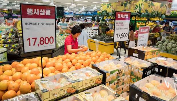 A customer looks at oranges on sale at an E-Mart Inc store in Seoul. Korean companies that were downgraded or got negative outlooks by S&P this month include E-Mart Inc.