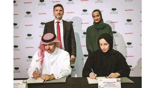 Buthaina Ali al-Nuaimi and Saleh al-Mana sign the MoU as HE Sheikha Hind bint Hamad al-Thani and Dominic Genetti look on.