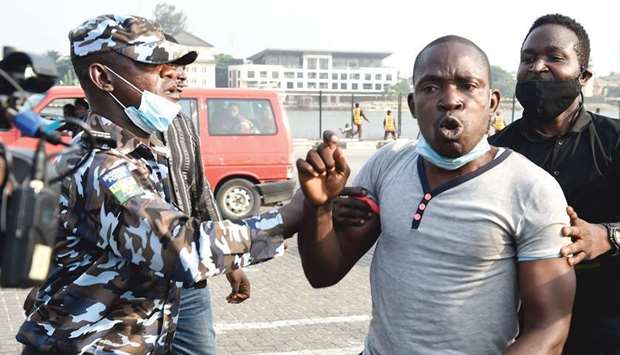 Police officers arrest a protester during a demonstration against police brutality, at the Lekki tollgate in Lagos, yesterday.