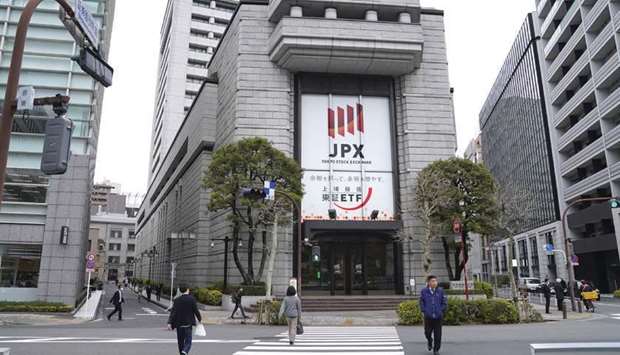 Pedestrians walk by the Tokyo Stock Exchange. The Nikkei 225 closed up 1.0% to 28,646.50 points yesterday.
